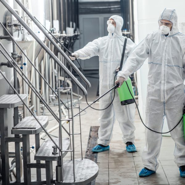 Covid-19,And,Sanitation.,Guys,In,Protective,Suits,And,Glasses,Disinfect