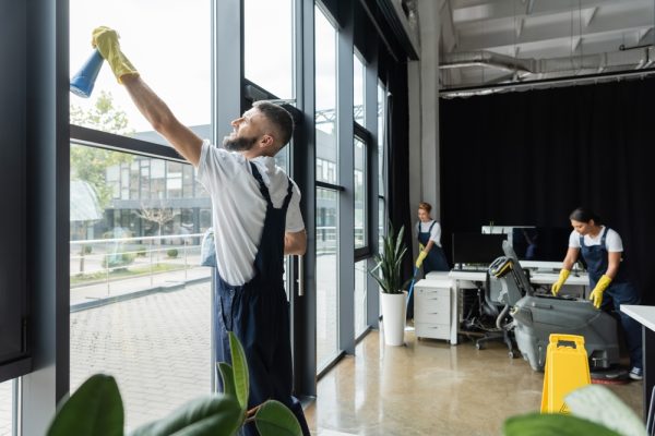 Bearded,Man,Washing,Office,Windows,Near,Interracial,Women,Working,On