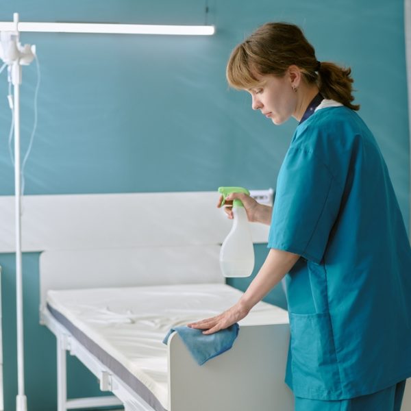 Caucasian,Young,Adult,Woman,Wearing,Medical,Scrubs,Cleaning,Hospital,Bed